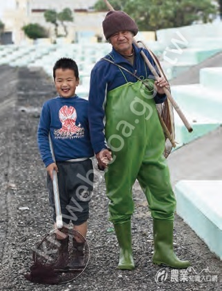 石滬達人柯進多帶孫子柯文元雙雙著裝，準備一同前往石滬抓魚。